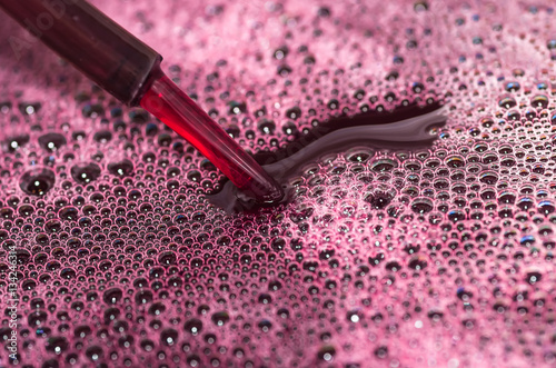 Bubbles of red wine closeup. Alcoholic background