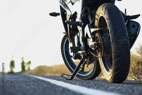A motorcycle parking on the road right side and sunset, select focusing background.