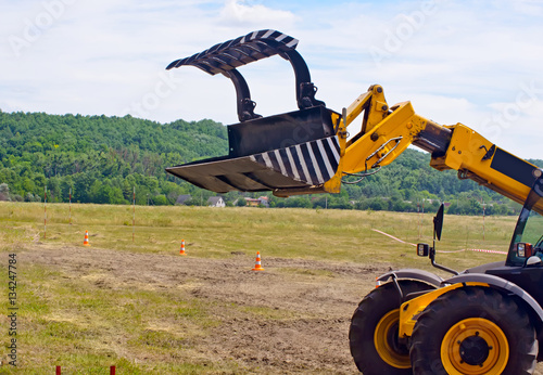 Bucket tractor yellow. Side view. photo