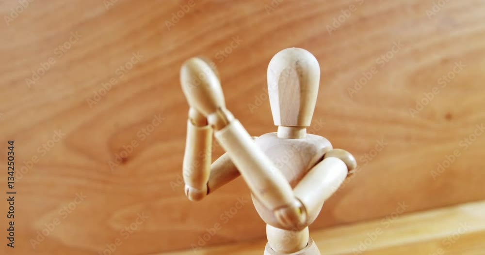 Figurine standing with arms crossed on a wooden floor Figurine standing with arms crossed on a wooden floor
