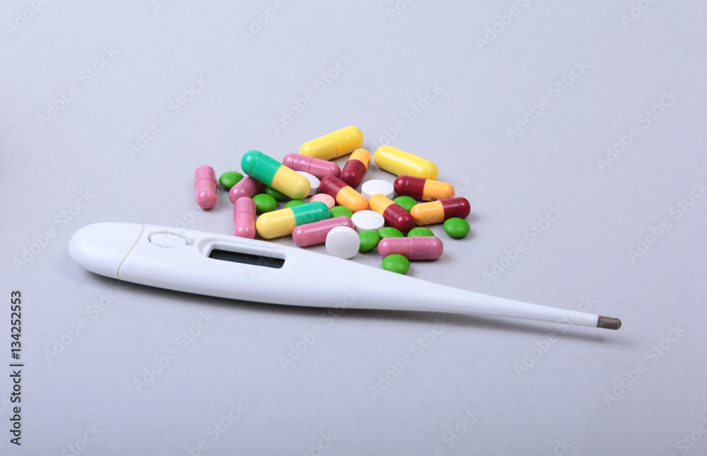 Pills and medical thermometer on white background. . Pills and medical thermometer on white background. .