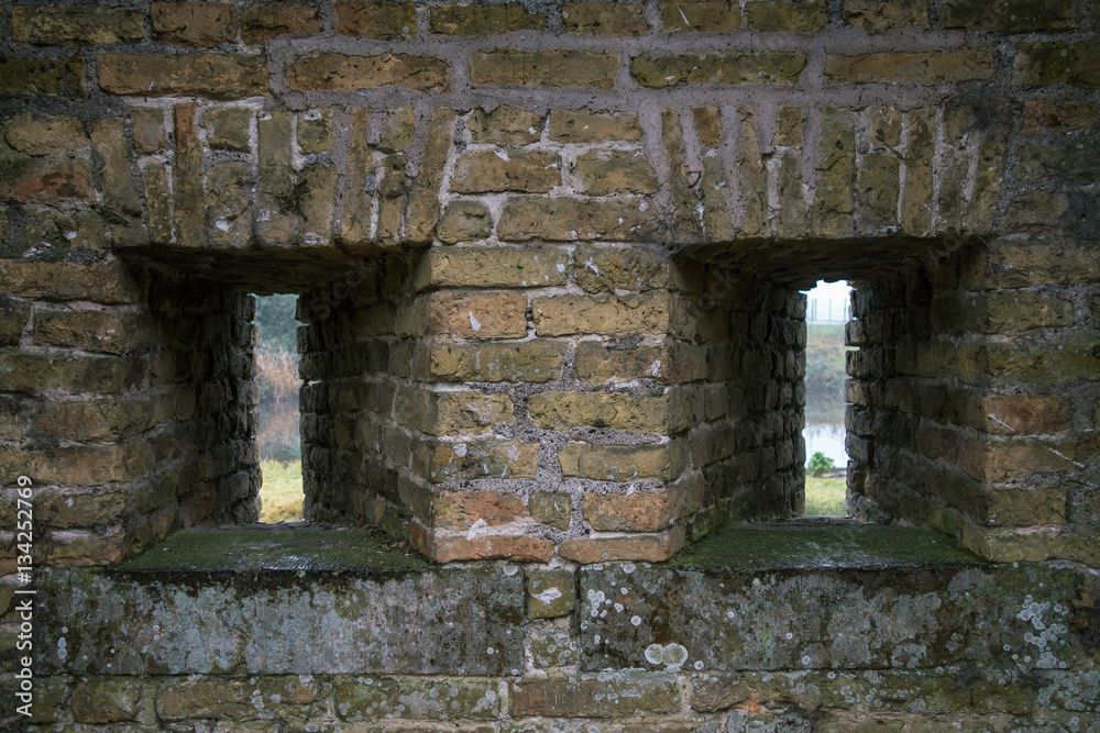 Two slits in the brick wall. France. City Bergues.