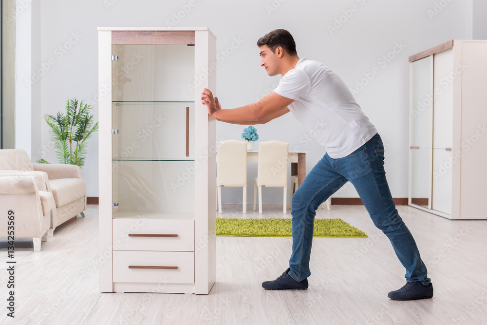 Man moving furniture at home Man moving furniture at home