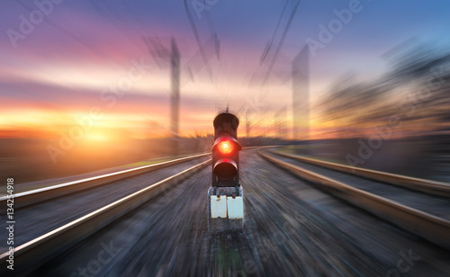 Quadro em tela Railway station and semaphore with motion blur effect against colorful sky with clouds at sunset