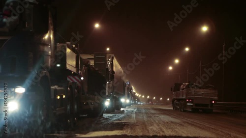 Long traffic jam is on winter federal road M10 at night time. Freight trucks stand to Moscow direction due road accident at slippery turn. Russia
