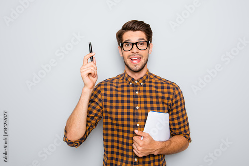 Smart  student in glasses  with great idea holding notebook and photo