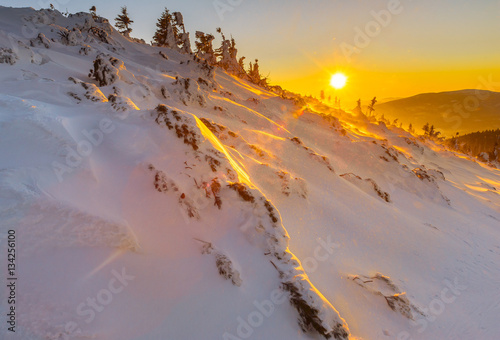 The light of sunset on the surface of snow in the mountains