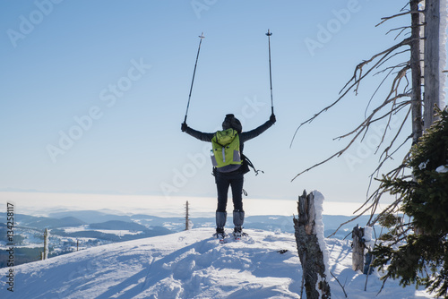 Ein Wanderer erkundet mit Schneeschuhen einen verschneiten Berg bei schönem Wetter