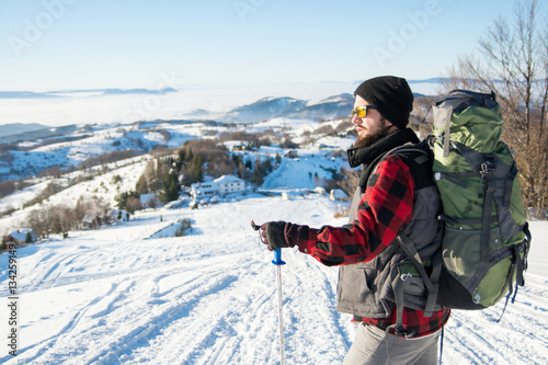 Bearded backpacker standing on the mountain
