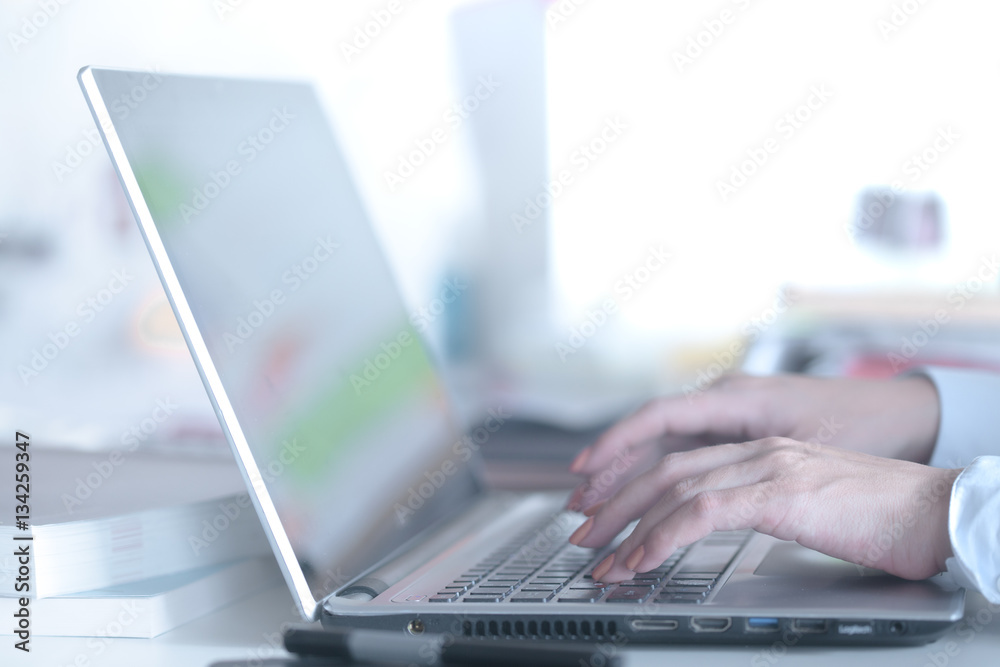 Female hands typing on a laptop