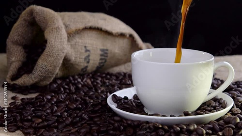 pouring fresh tasty coffee into cup