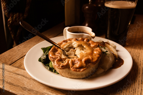 Traditional savory chicken pot pie served in pub with beer in the background photo