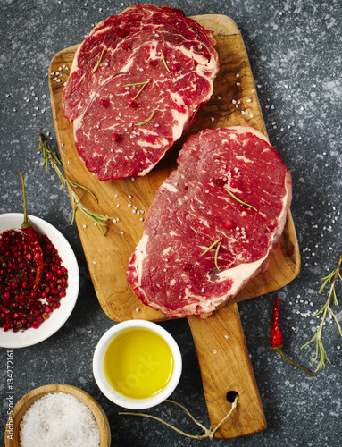 Raw fresh meat Ribeye Steak with rosemary, pepper, salt and oliv