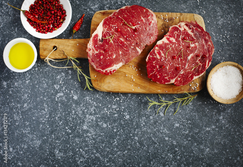 Raw fresh meat Ribeye Steak with rosemary, pepper, sea salt and