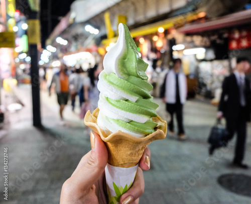 Ice cream cone held up in the city