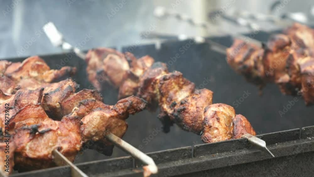 Cooking of pork shashlik on skewers on the grill outdoors. Close up Cooking of pork shashlik on skewers on the grill outdoors. Close up
