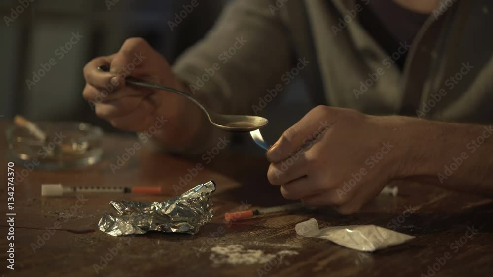 Impatient drug addict withdrawing heroin dose from spoon with syringe, sequence