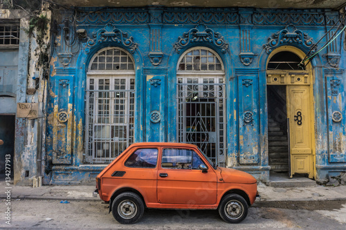 old small car in front old blue house, general travel imagery, on december 26, 2016, in La Havana, Cuba