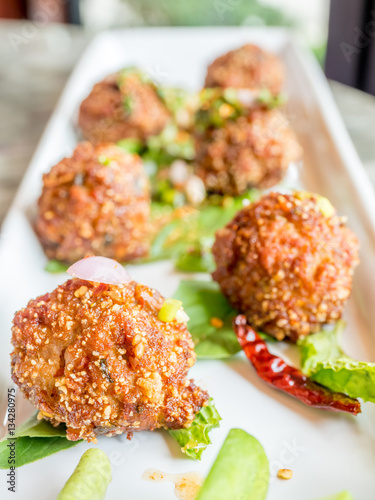 Thai spicy meat ball on white dish photo