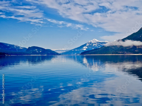 Fototapeta Naklejka Na Ścianę i Meble -  Blue lake and blue snowy mountains. Upper Arrow lake. Columbia River.  Selkirk and Monashee Mountains.  Keenleyside Dam. Castlegar. Revelstoke. British Columbia. Canada.