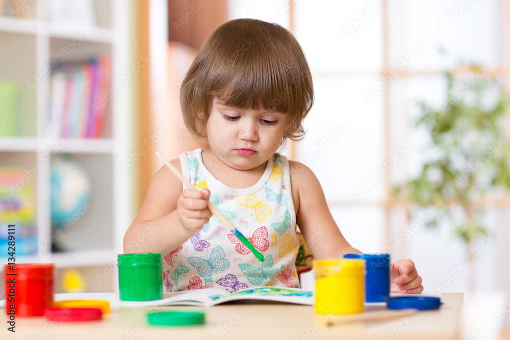 Little girl painting in school or daycary center. Education. Little girl painting in school or daycary center. Education.