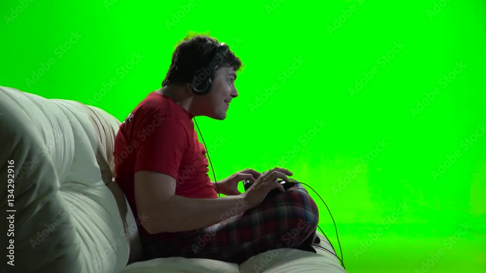 Guy playing computer games sitting on the sofa. Green screen Guy playing computer games sitting on the sofa. Green screen