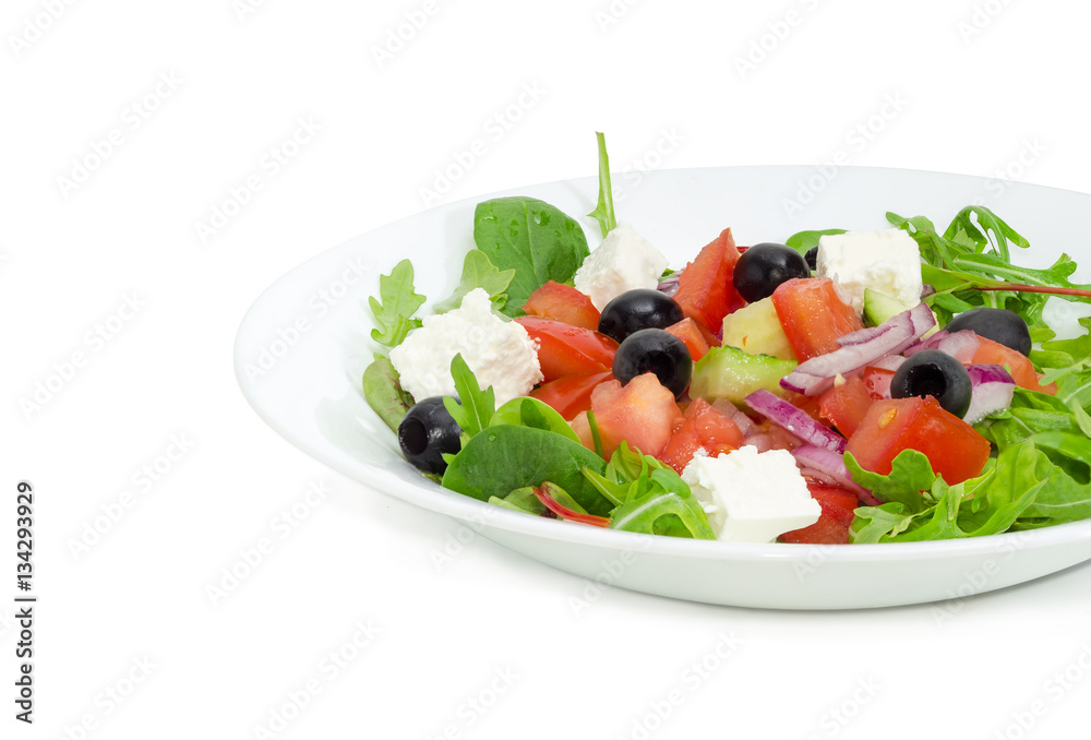 Greek salad in a white dish on a light background