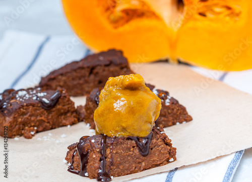 Pumpkin vegan brownie with a scoop of pumpkin ice cream and chocolate. Love for a healthy desserts concept.