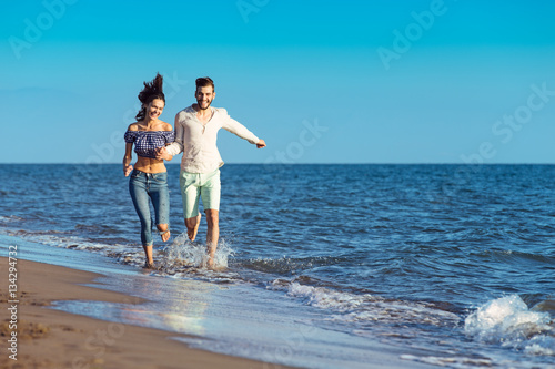 happy couple running on the beach