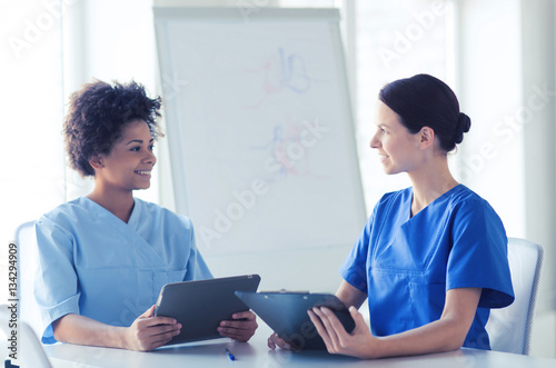 happy doctors with tablet pc meeting at hospital