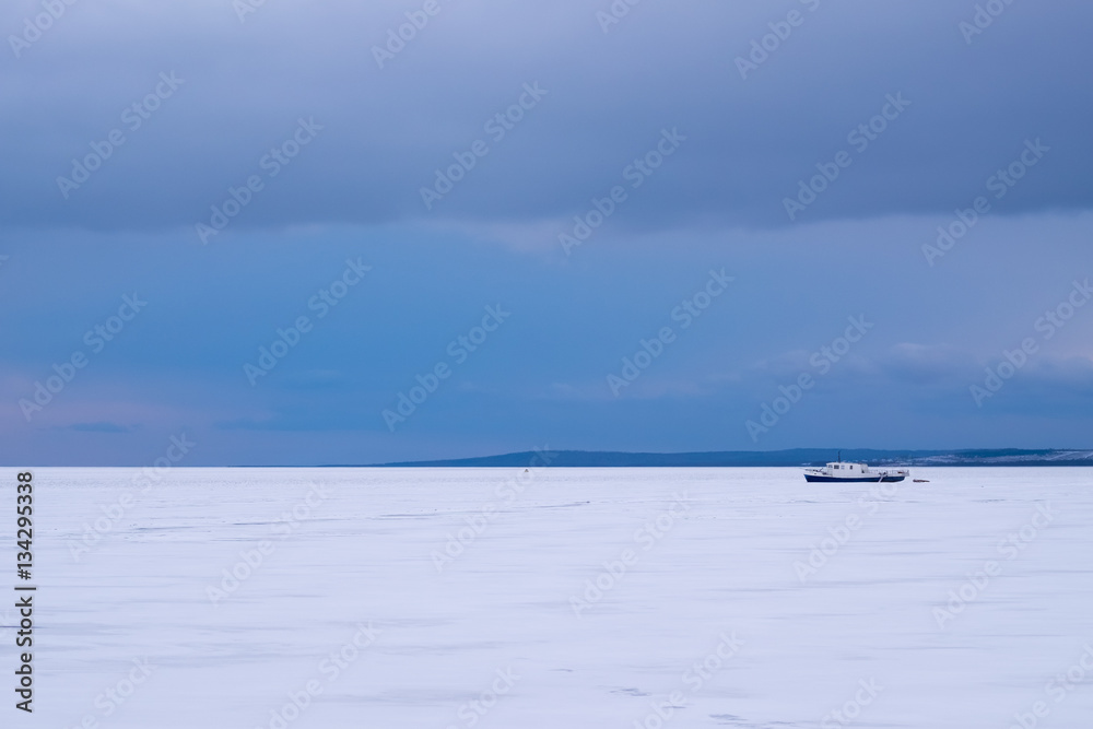 Frozen Lake Baikal, fishing boat in the ice