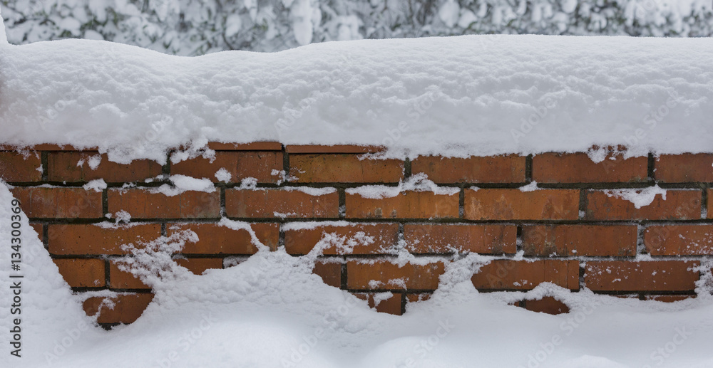 Fototapeta premium Red brick wall covered with snow