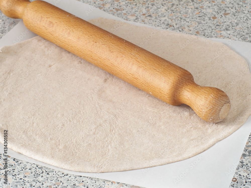 Cooking process. Preparing pizza or pie crust. Rolled out homemade wholegrain dough. Cooking process. Preparing pizza or pie crust. Rolled out homemade wholegrain dough.