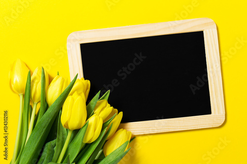 Fresh beautiful yellow tulips on yellow colorful background with