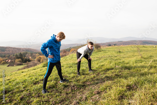 Two young hipster runners in sunny autumn nature restinng