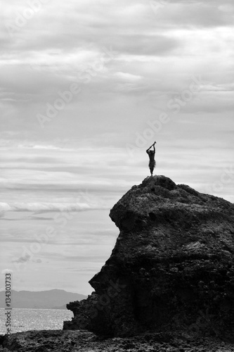 Silhouette of unrecognizable Fijian man stands on a sea cliff in Fiji
