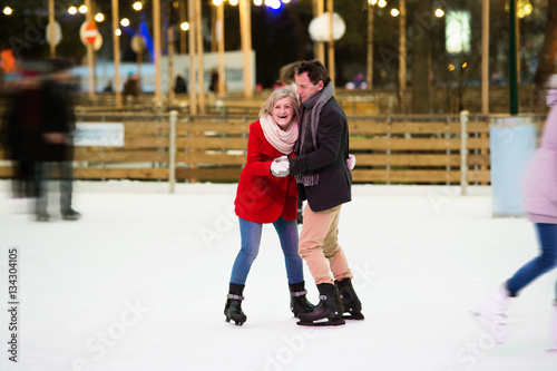 Beautiful senior couple ice skating in city centre. Winter