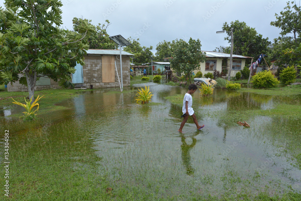 Fijian girl walks over flooded land in Fiji