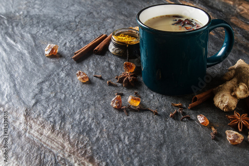 Traditional Indian masala tea in ceramic cup with spices to milk