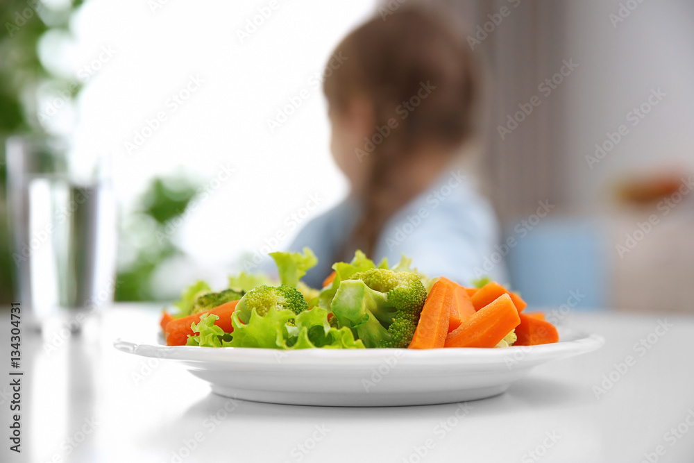 Plate with vegetable salad on kitchen table