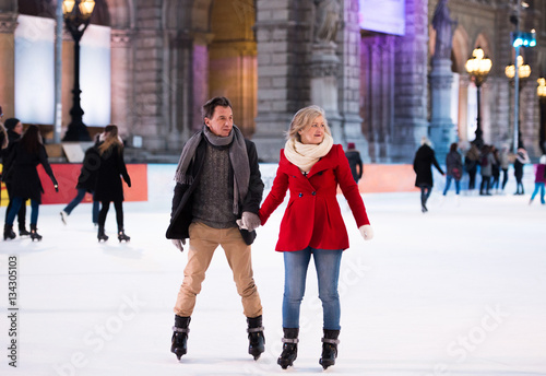 Photography Beautiful senior couple ice skating in city centre. Winter