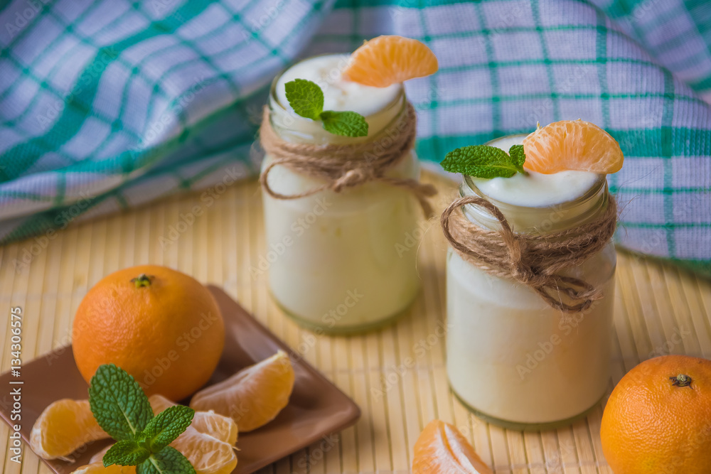 Fresh organig natural white yogurt in glass jars with tangerine Fresh organig natural white yogurt in glass jars with tangerine