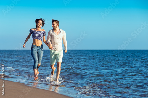 happy couple running on the beach