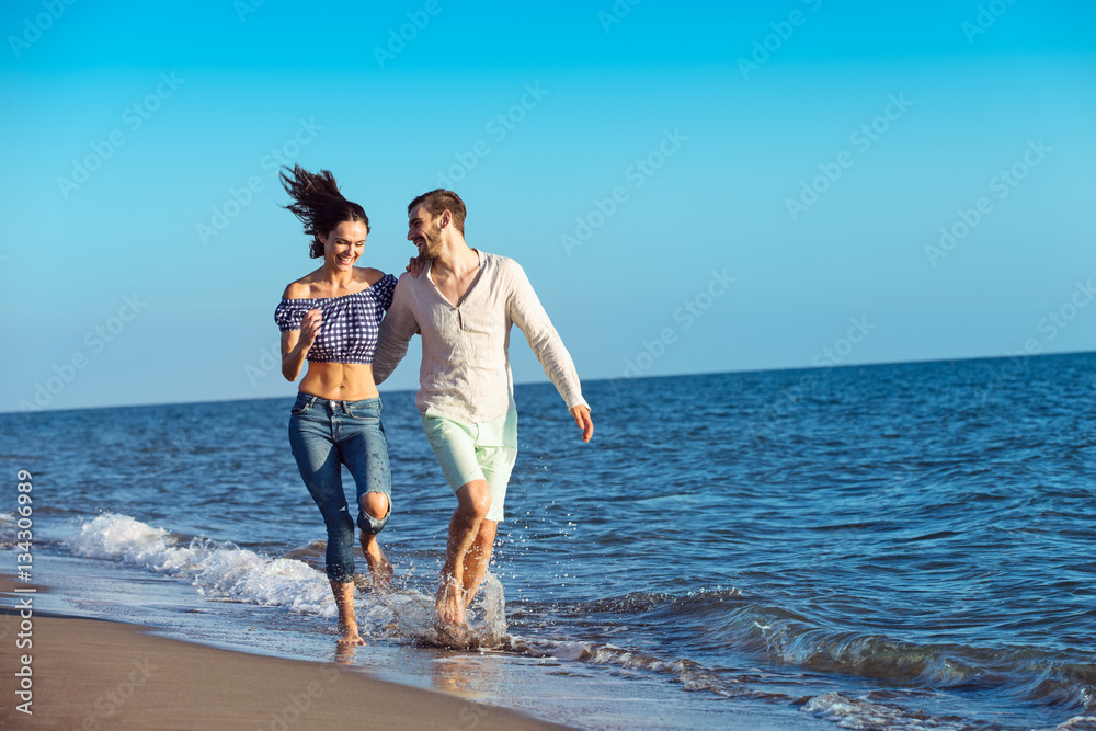 happy couple running on the beach