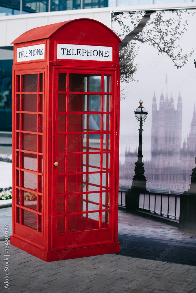 The London red public callbox stands on the sidewalk The London red public callbox stands on the sidewalk