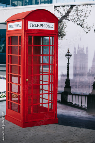 The London red public callbox stands on the sidewalk