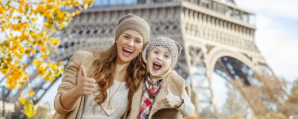 Fototapeta premium mother and child travellers in Paris, France showing thumbs up