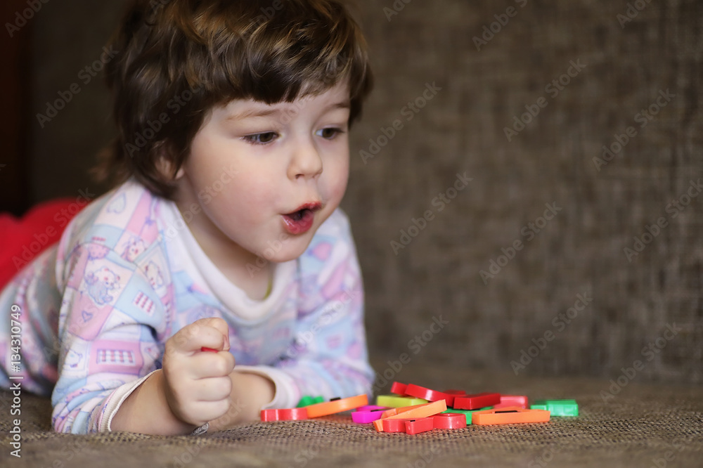 child playing with small toys on the couch in room child playing with small toys on the couch in room