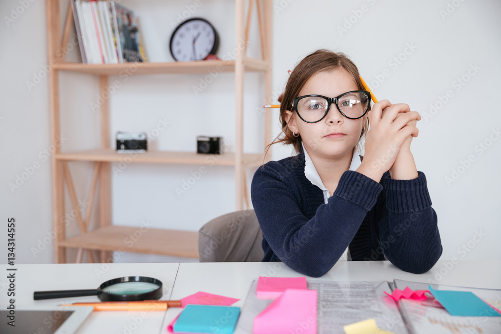 Girl sitting at table with sticky notes and magnifying glass Girl sitting at table with sticky notes and magnifying glass