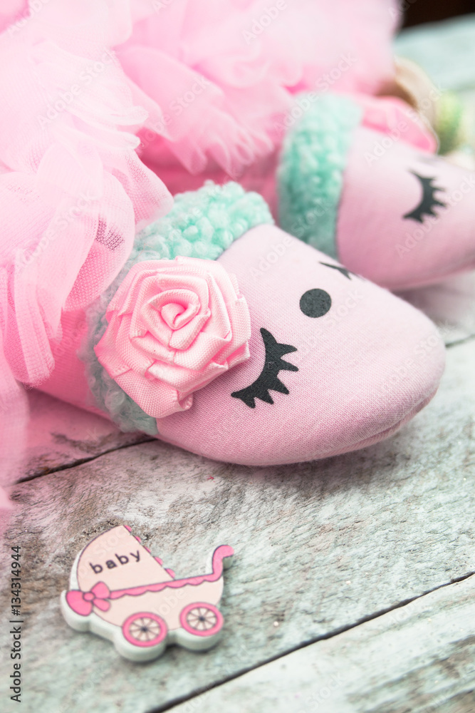 Pink little girlie baby shoes on a wooden floor Pink little girlie baby shoes on a wooden floor